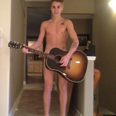 A nude awakening: New pictures have emerged showing Justin Bieber naked and covering his modesty with a guitar during a bizarre Thanksgiving prank. (Photo courtesy TMZ)