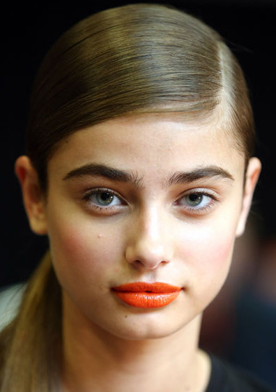 Add a pop of color with orange lipstick (Photo: Getty Images)