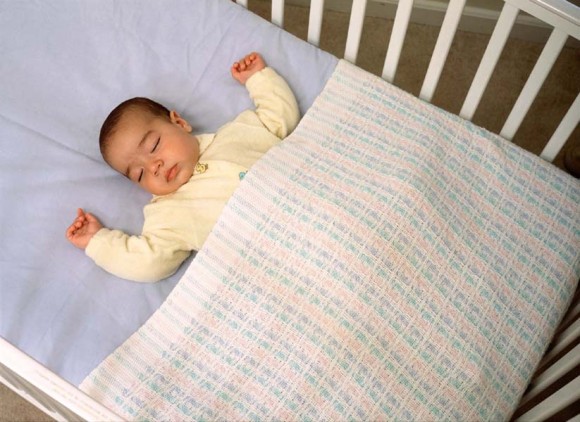 If you must use a blanket with an infant, tuck it in tightly along the sides and bottom of the crib and no higher than the baby’s armpits. (Photo: Private Health Visitor)