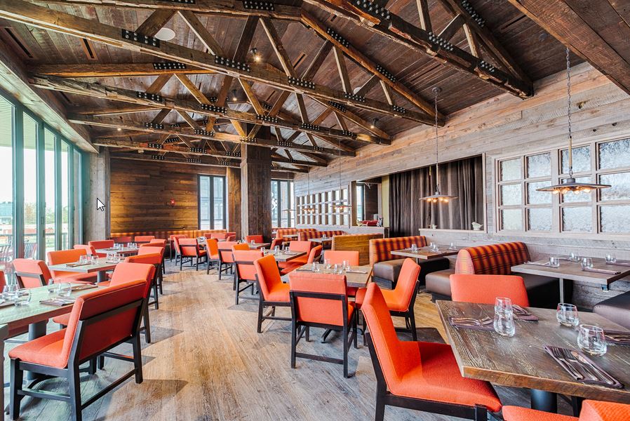 City Perch's main dining room decorated with dark woods and orange chairs is light filled. (Photo: R. Lopez)