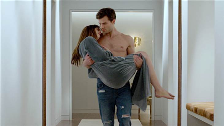 Christian Grey (Jamie Dornan) carries Anastasia Steele (Dakota Johnson) in Fifty Shades of Grey." (Photo: Universal Pictures)