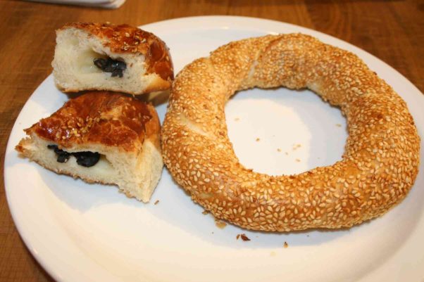 A simit, left, is similar to a bagel except it is dipped in grape oil and sesame seeds before it is baked -- not boiled. The poğaça  (left) resembles focaccia stuffed with kasseri cheese and black olives. (Photo: Mark Heckathorn/DC on Heels)