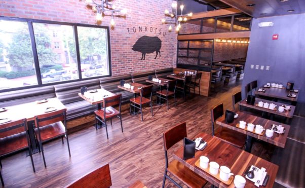 The upstairs dining room features dark woods, exposed brick and a pig mural. (Photo: Peter Stepanek)