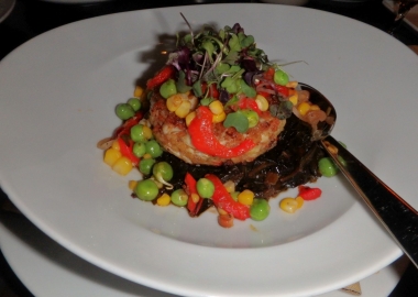 Jardenea's Maryland crab cake is served over Appalachian corn, roasted red peppers, smoked bacon and the best apple cider braised collard greens you will ever taste. (Photo: Nick Bullock/DC on Heels)