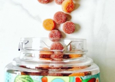 Red and orange gummy vitamins spillingout of a jar onto a table. (Photo: Olly Nutrition/Instagram)