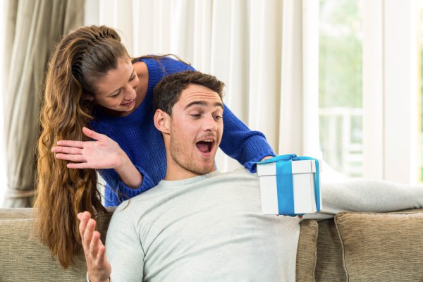 Woman giving man a surprise gift. (Photo: Wavebreak Media)