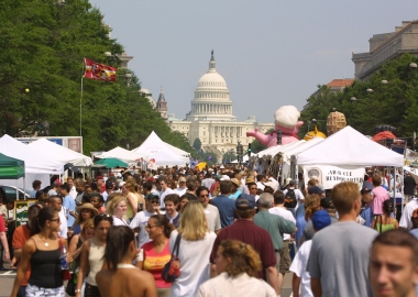 Crowds walking along Pennsylvania Avenue between vendors with the U.S. Capitol inthe background (Photo; National Capital Barbecue Battle)