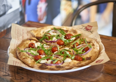 The Isaac pizza has an olive oil base topped with garlic, ricotta cheese, sliced red onion and roasted red tomatoes finished with a swirl of balsamic vinaigrette and topped with fresh basil (Photo: MOD Pizza)