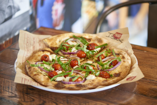 The Isaac pizza has an olive oil base topped with garlic, ricotta cheese, sliced red onion and roasted red tomatoes finished with a swirl of balsamic vinaigrette and topped with fresh basil (Photo: MOD Pizza)