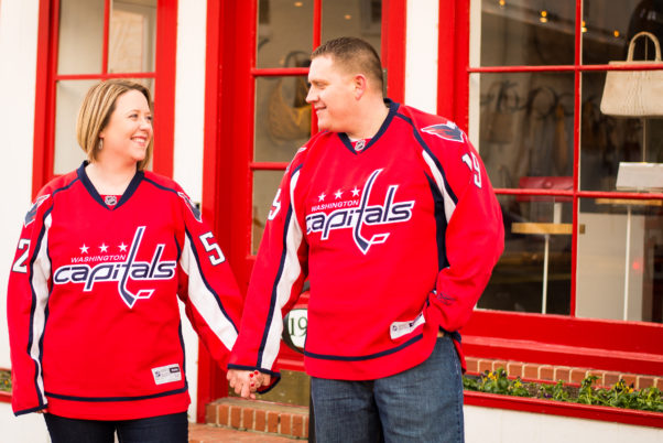 A woman and man holding hands outside dressed in Washington Capitals jerseys. (Photo: Eastport Photography)