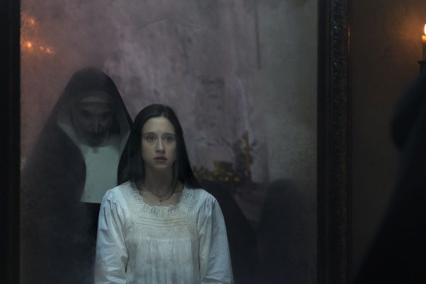 The evil nun looking over the shoulder of another nun in a mirror in The Nun. (Photo: Warner Bros. Pictures)