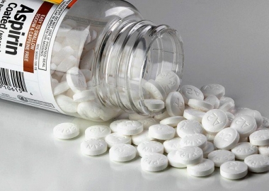 a bottle of aspirin on its side with pills spilling onto the table. (Photo: iStock)