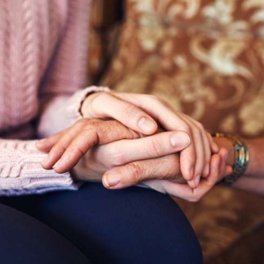 Cropped shot of unrecognizable women holding hands at home. (Photo: iStock)