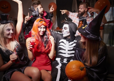 Three men and three women dressed in Halloween Costumes including witch, skelton and vampire at a house party. (Photo: Shutterstock)