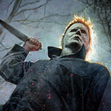 Mike Myers standing in front of trees with a knife raised in the air. (Photo: Universal Pictures)