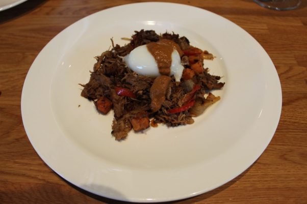 Texas hash made with coffee-brined pork, sweet potatoes, peppers, onions, a poached egg topped with pecan mole from Paperboy in Austin, Texas. (Photo: Mark Heckathorn/DC on Heels