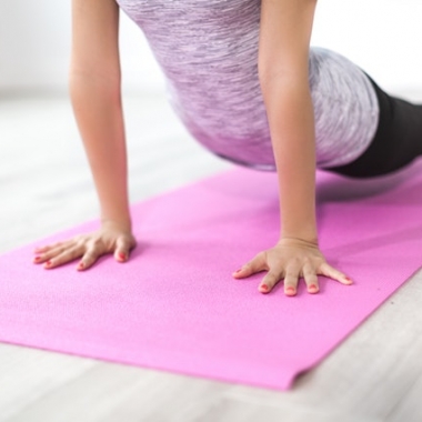 A woman on a pink yoga mat pushing her shoulders up with her arm with her legs on the ground. (Photo: Burst/Pexels)