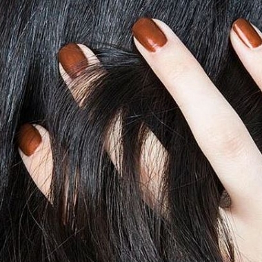 A close up of a woman with running her hand through her black hair. The four fingers you can see are painted a copper color. (Photo: Narsissist/Instagram)