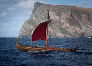 The Viking ship Draken Harald Hårfagre sailing past a cliff. (Photo Viking Nilsson):