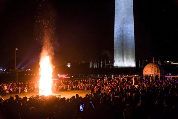 People gather around the Catharsis on the Mall's "Temple Burn" in front of the Washington Monument with flames shooting into the air. (Photo: Catharsis on the Mall)
