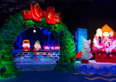 Ice cavrings of Snoopy lying on his dog house while Charlie Brown and Linus lean on a wall looking through a giant werath with a red bow. (Photo: Gaylord National Resort)