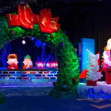 Ice cavrings of Snoopy lying on his dog house while Charlie Brown and Linus lean on a wall looking through a giant werath with a red bow. (Photo: Gaylord National Resort)
