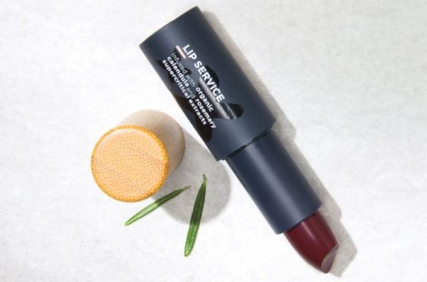 A tube of Lip Service lipstick in Galaxy with some leaves. (Photo: The Organic Skin Co.)