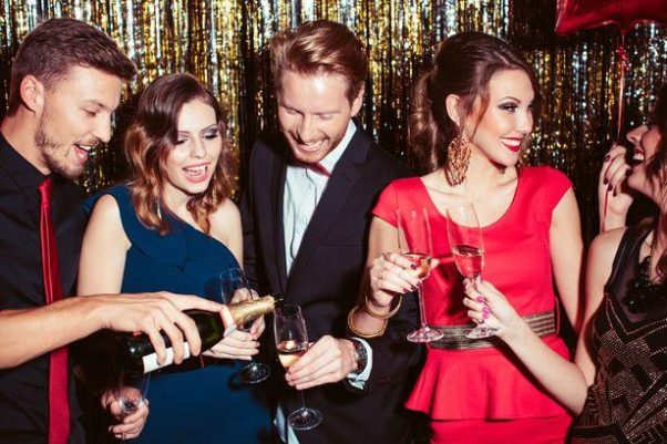 Two men and three women having a champagne toast at a New Year's Eve party. (Photo: Getty Images)