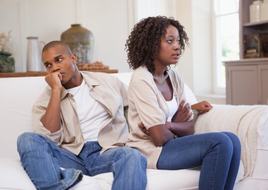 Black couple arguing on a couch. (Photo: Shutterstock)