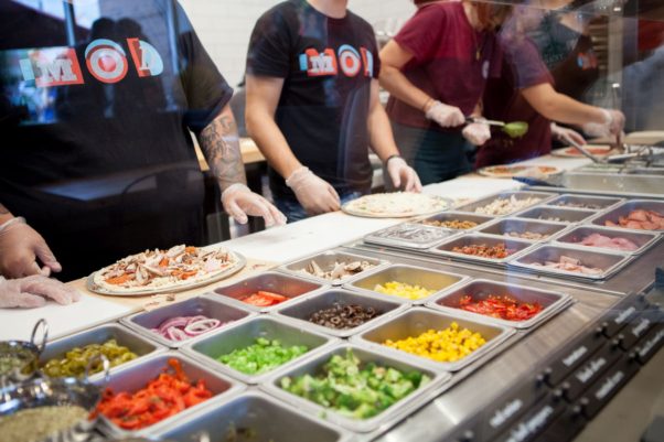 MOD Pizza employees lined up making pizzas assembly line style. (Photo: MOD Pizza)