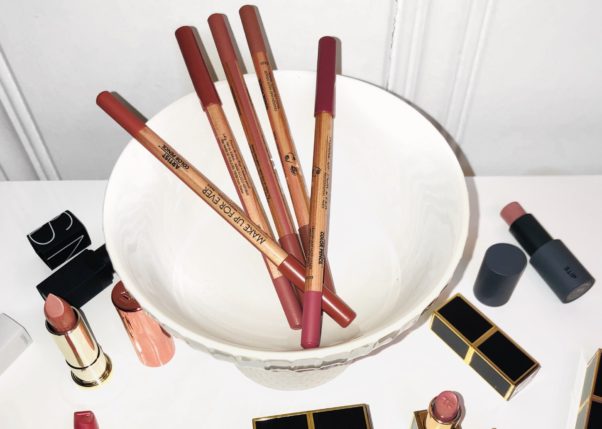 Items mentioned in the article including pencils, lipsticks, highlighting sticks and lip paints scattered on a table. (Photo: Sarah Howard)
