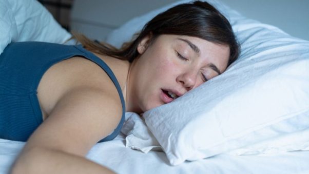 Woman sleeping on her stomach snoring. (Photo: Shutterstock)