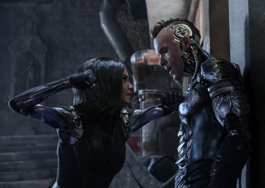 Alita (Rosa Salazar) has Zapan (Ed Skrein) pinned against a wall about to punch him. (Photo: 20th Century Fox)