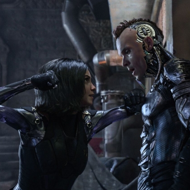 Alita (Rosa Salazar) has Zapan (Ed Skrein) pinned against a wall about to punch him. (Photo: 20th Century Fox)