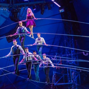 Seven tight rope walkers walk in pyramid formation balancing on each other across the tight rope. (Photo: Big Apple Circus)