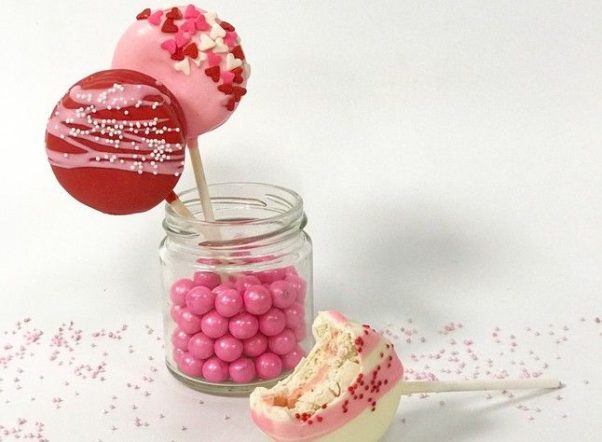 The decorated macaron pops in pink, red and white with candy hearts. (Photo: Buttercream Bakeshop)