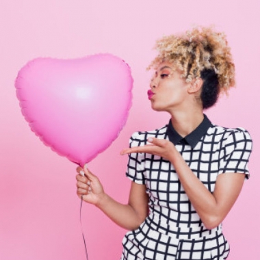 Young woman with big pink heart balloon. (Photo: Getty Images)