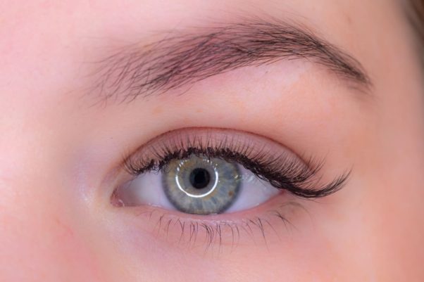 A close up of a green eye with long, thick lashes. (Photo: The Lash Spa)