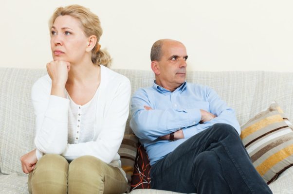 An older couples sitting on a couch after an arguement looking in different directions. (Photo: Getty Images)