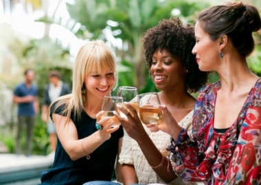Three women friends sitting in a garden making a toast. (Photo: PicBon)