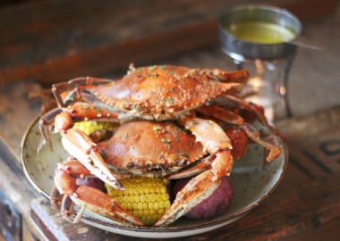 3 crabs on top of potatoes and corn on the cob on a plate. (Photo: Morgan West)