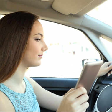 Teen female driver looking at her cell phone while driving. (Photo: Getty Images)