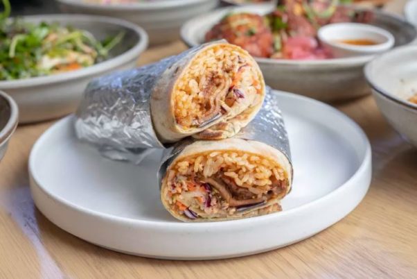 A bing breard wrap with  rotisserie pork shoulder on a white place. (Photo: Momofuku CCDC)