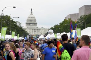 Visitors stop at booths set up along Pennsylvania Avenue with the U.S. Capitol in the background at 2018's Capital Pride Festival. (Photo: Metro Weekly)