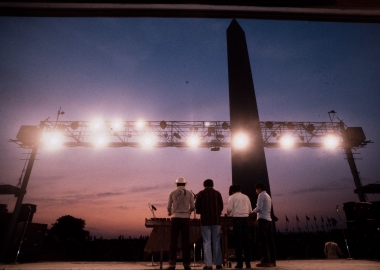 Four singers on a stage on the National Mall with their backs to the camera and the Washington Monument in the background. (Photo: Smithsonian Folklife Festival)