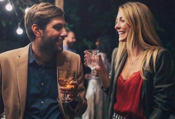 A Caucasin couple laughing and sharing drinks. (Photo: Lumina)
