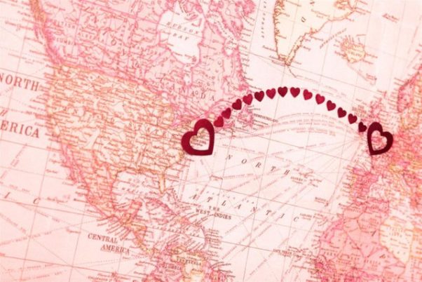 Pink map showing Atlantic Ocean with line made from hearts from Great Britain to the US. (Photo: PeskyMonkey/Getty Images)