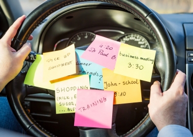 Sticky notes with different reminders stuck on the middle of a steering wheel. (Photo: Shutterstock)