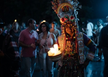 A female Native American dressed in animal skins holds candles at the National Museum of the American Indian. (Photo: National Museum of the American Indian)