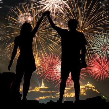Sillouette of two people holding hands with fireworks in the background. (Photo: Dreamstime)